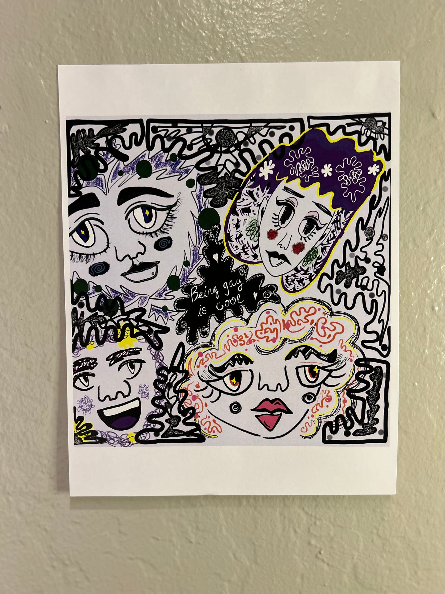 Photo of "being gay is cool" print hanging frameless on a wall.